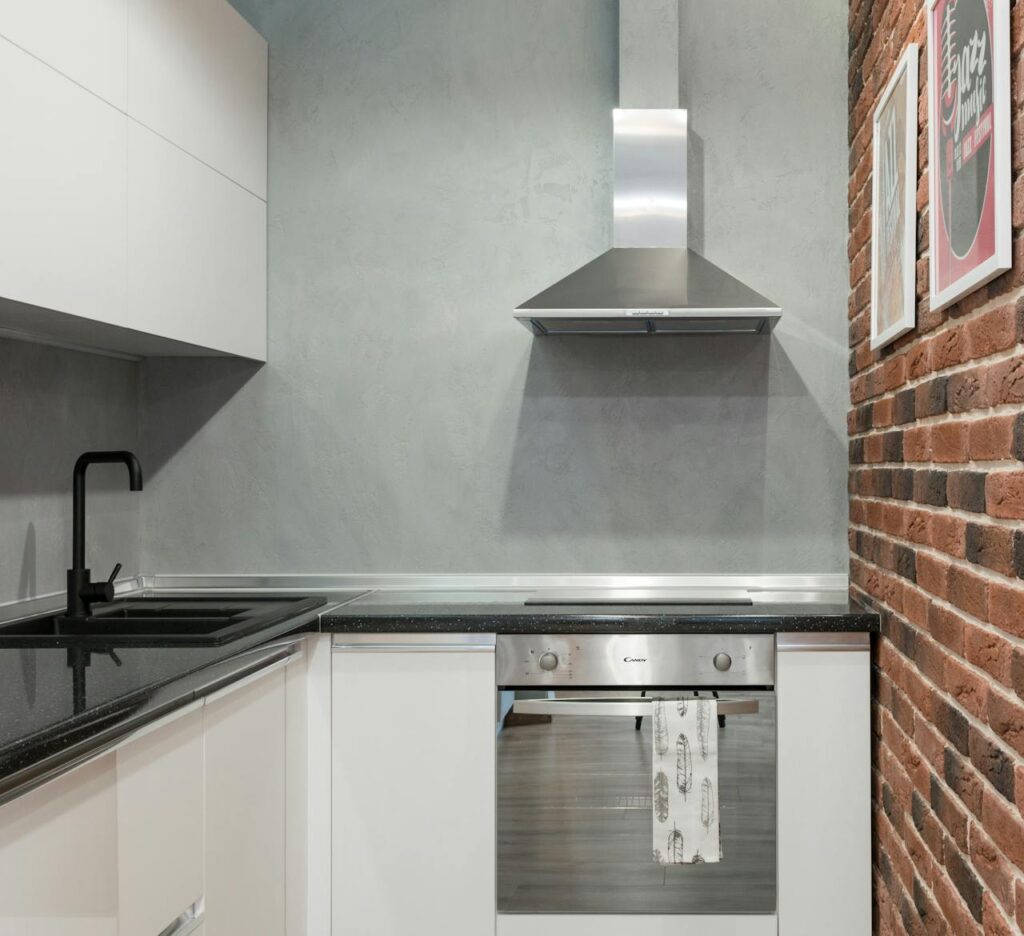 pexels-photo-7214729 Contemporary kitchen interior with stainless steel appliances and brick wall.