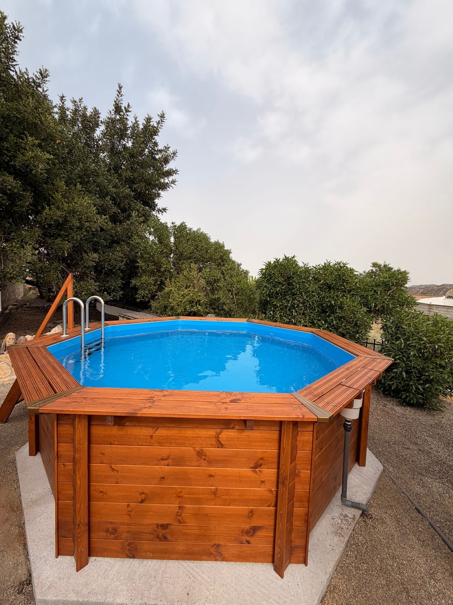 Piscina elevada con revestimiento de madera y escalera de acceso.